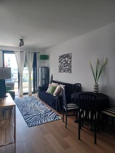 uma sala de estar com um sofá azul e uma mesa em Apartment Gabi em Zadar