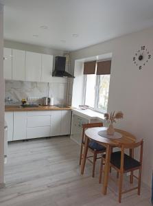 a kitchen with a table and a table and chairs at Vytekstos Apartamentai in Druskininkai