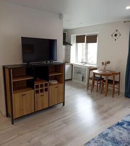 a living room with a flat screen tv on a entertainment center at Vytekstos Apartamentai in Druskininkai