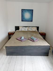 a bed with two towels on top of it at Vytekstos Apartamentai in Druskininkai