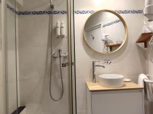 a bathroom with a shower with a sink and a mirror at Hotel Cap d'Or in Tossa de Mar