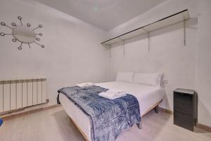 um pequeno quarto com uma cama e uma televisão em La Ciudadela by Clabao em Pamplona