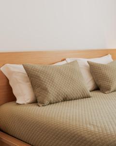 Una cama con cuatro almohadas encima. en Quinta da Quinhas, en Vila Praia de Âncora