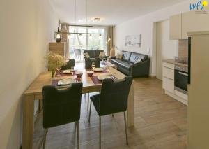 a kitchen and living room with a table and chairs at Haus Oldenburg Ferienwohnung 5 in Wangerooge