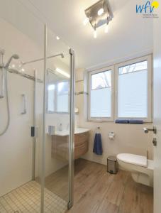 a bathroom with a shower and a toilet and a sink at Haus Oldenburg Wangerooge 50709 in Wangerooge