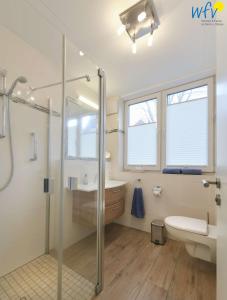 a bathroom with a shower and a toilet and a sink at Haus Oldenburg Ferienwohnung 5 in Wangerooge +21 photos