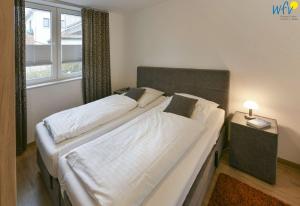 a bedroom with two beds and a window at Haus Oldenburg Ferienwohnung 5 in Wangerooge