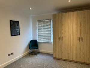 a room with a door and a chair and a window at Cromwell Court Apartments in Huntingdon