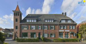 a large brick building with a clock tower at Alte Feuerwache Ferienwohnung 1 in Wangerooge