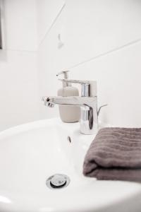 um lavatório de casa de banho com uma torneira e uma toalha em Apartment Hafenarbeiter em Bremerhaven