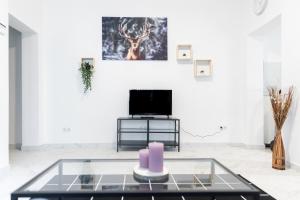 uma sala de estar com uma mesa de vidro e uma televisão em Apartment Hafenarbeiter em Bremerhaven