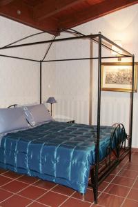 1 dormitorio con cama con dosel y edredón azul en Masseria Mofetta, en Acquaviva delle Fonti