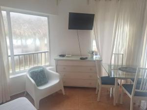 um quarto com uma secretária, uma mesa e uma janela em Appartamento Martinic Juan Dolio fronte mare em Juan Dolio