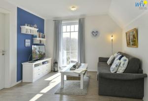ein Wohnzimmer mit einem Sofa und einem TV in der Unterkunft Bootshaus in den Duenen - 5 Bootshaus in den Duenen Wangerooge - 5 in Wangerooge