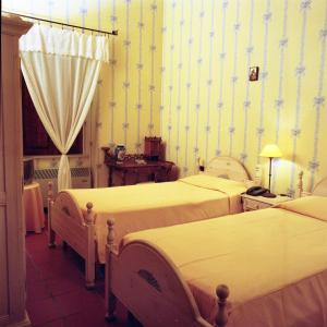 1 dormitorio con 2 camas en una habitación con papel pintado en Masseria Mofetta, en Acquaviva delle Fonti