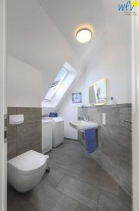 ein Badezimmer mit einem weißen WC und einem Waschbecken in der Unterkunft Bootshaus in den Duenen - 5 Bootshaus in den Duenen Wangerooge - 5 in Wangerooge