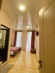 a room with a hallway with a bed and windows at Moedani-Very Center Apartments in Kutaisi in Kutaisi