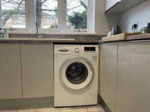 a kitchen with a washing machine in a kitchen at 1 bed apartment in the park a quiet enclave in Nottingham