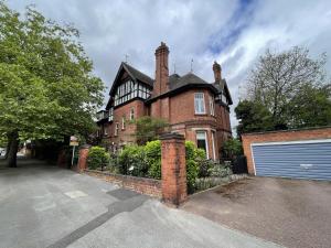 a large brick house with a gate and a garage at 1 bed apartment in the park a quiet enclave in Nottingham