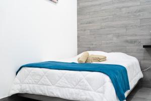 a bed with a blue and white blanket on it at Casa da Carochinha in Nazaré