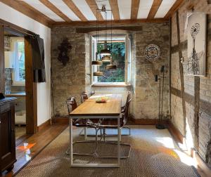 een eetkamer met een tafel en stoelen en een raam bij Ferienwohnung Mühlenstube in Mösbach