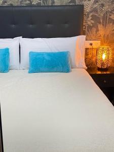 1 cama grande con 2 almohadas azules en Gran Vía Urban Apartments, en Madrid