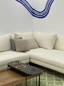 - un canapé blanc avec une table basse dans le salon dans l'établissement cozy apartment, à La Marsa