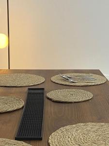 une table en bois avec quatre plaques circulaires, dans l'établissement cozy apartment, à La Marsa