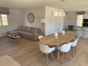 a kitchen and living room with a wooden table and chairs at Les Collines de Saint-André in Saint-André-de-Cruzières +8 photos