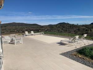 a patio with chairs and a view of mountains at Les Collines de Saint-André in Saint-André-de-Cruzières