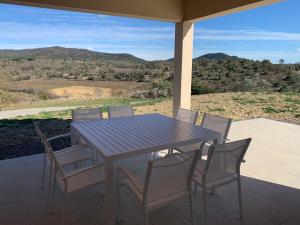 a table and chairs sitting on a porch with a view at Les Collines de Saint-André in Saint-André-de-Cruzières