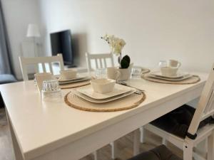a white table with plates and dishes on it at Appartement F2 proche Paris CDG/parc expos/RER B in Sevran