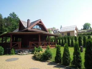 une maison avec un aménagement paysager d'arbres et un bâtiment dans l'établissement Domki nad Jeziorem Ołów, à Ryn