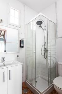 y baño blanco con ducha y aseo. en Granada FreshApartments by Bossh! Apartments, en Málaga