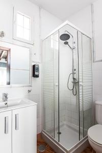 a white bathroom with a shower and a toilet at Granada FreshApartments by Bossh! Apartments in M&aacute;laga