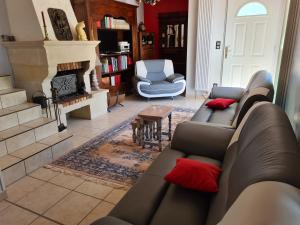 a living room with a couch and a fireplace at GITE DE CHARME in Changey