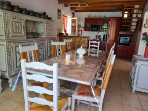 a kitchen with a wooden table and chairs at GITE DE CHARME in Changey