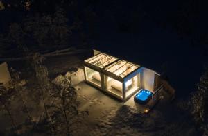 una vista aérea de una pequeña casa de cristal por la noche en Northern Lights Ranch, en Levi
