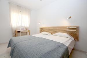 a bedroom with a bed with a blue blanket at Estepona Town Apartment CARMEN in Estepona +17 photos