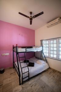 um quarto com 2 beliches e uma ventoinha de tecto em Tranquil Homestay em Mangalore
