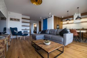 a living room with a couch and a table at Apartview Bukowa III by Rent like home in Wisła