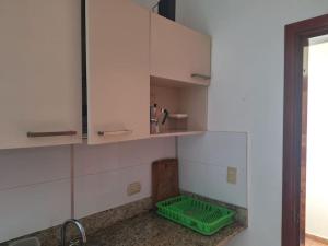 eine Küche mit weißen Schränken und einem grünen Waschbecken in der Unterkunft Appartamento Caribe Juan Dolio Fronte Mare in Juan Pedro