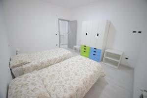 een slaapkamer met 2 bedden en een dressoir bij Il nascondiglio in San Ferdinando di Puglia