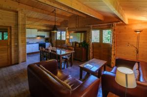 a living room and kitchen in a log cabin at Domaine de Maples in Dore-lʼÉglise