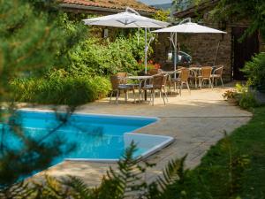 a patio with a table and chairs and an umbrella at Domaine de Maples in Dore-lʼÉglise +9 photos