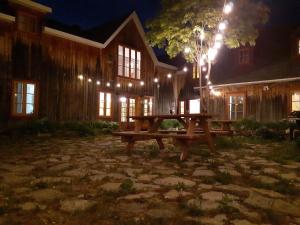 una mesa de picnic frente a una casa por la noche en Auberge Le P'tit Bonheur, en Saint-Laurent-de-l'ile d'Orleans