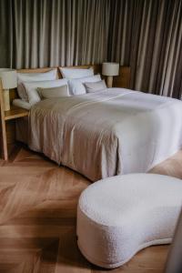 1 dormitorio con 1 cama grande con almohadas blancas en Hotel Schloss Teutschenthal, en Teutschenthal