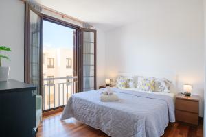 a bedroom with a white bed and a large window at Suite Yagabo in Arrecife