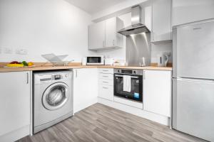 SleightholmeにあるNew Modern 2 Bedroom Apartment - WIFI & Netflix - Secure Parking - 27ACのキッチン(白いキャビネット、洗濯機、乾燥機付)