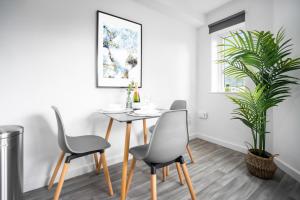 a dining room with a table and chairs and a plant at New Modern 2 Bedroom Apartment - WIFI & Netflix - Secure Parking - 27AC in Sleightholme